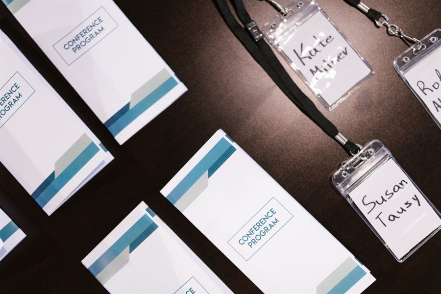 Conference programs and handwritten name badges on lanyards