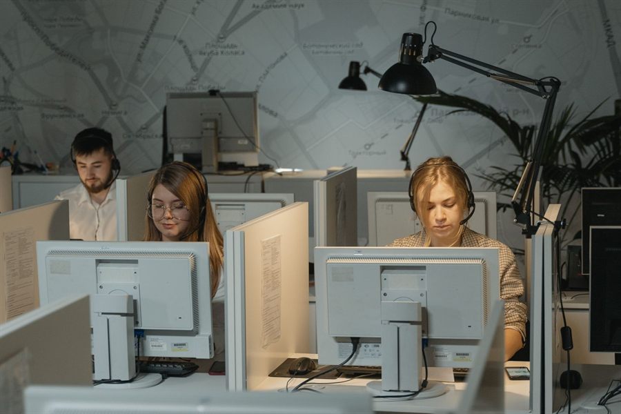 Agents with headsets working at computers in an office